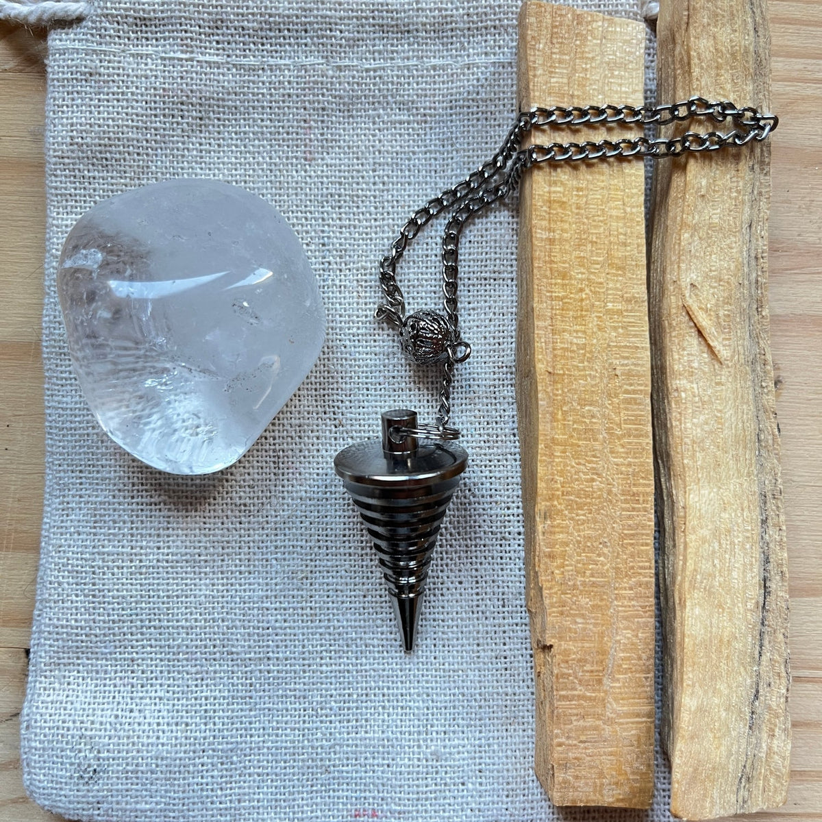 Kit para empezar con el péndulo: péndulo metálico, cuarzo cristal rodado y varitas de palo santo