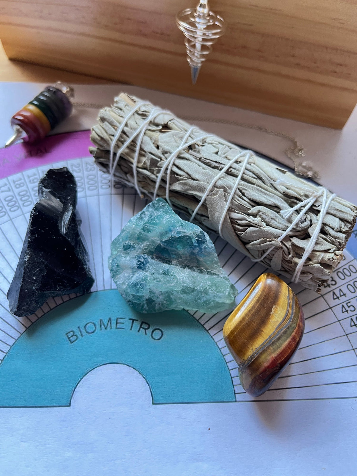 Sesión de radiestesia con salvia blanca, obsidiana, fluorita y ojo de tigre. El péndulo no está incluido en el pack